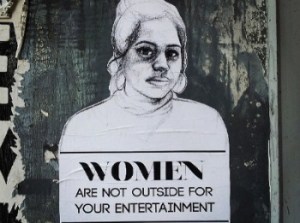[Image: drawing of a woman with the words “Women are not outside for your entertainment.”]